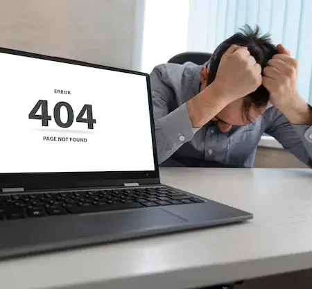 A person sitting in front of a computer screen showing “404 Page Not Found” error with a confused look.